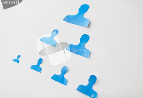 Image of close up of paper human shapes on white board