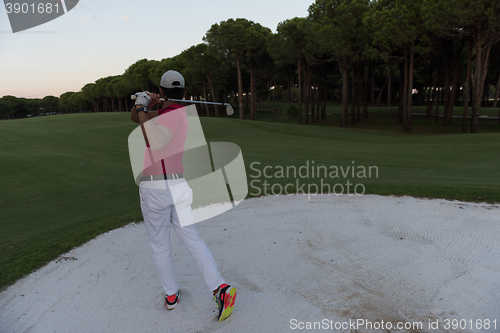 Image of golfer hitting a sand bunker shot on sunset