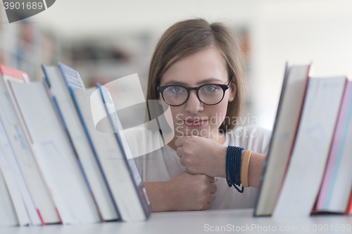 Image of portrait of famale student selecting book to read in library