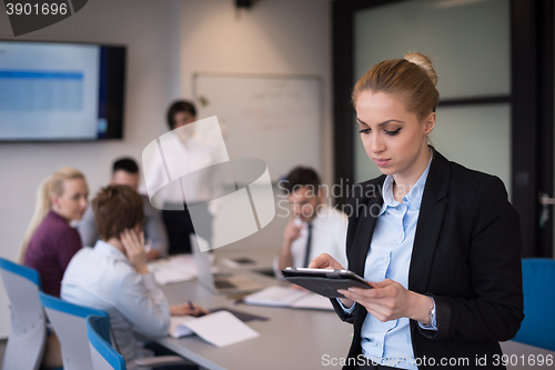 Image of business woman working on tablet at meeting room