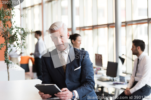 Image of senior business man working on tablet computer