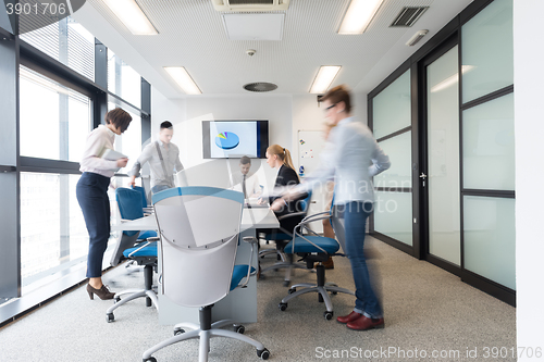 Image of business people group entering meeting room, motion blur