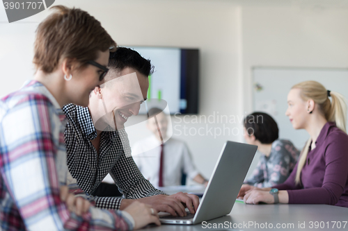 Image of young business couple working on laptop, businesspeople group on
