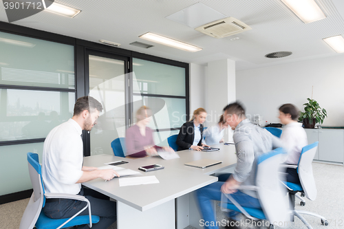 Image of business people group entering meeting room, motion blur