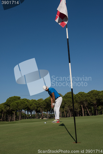 Image of golf player hitting shot at sunny day
