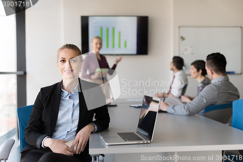 Image of portrait of young business woman at office with team on meeting 
