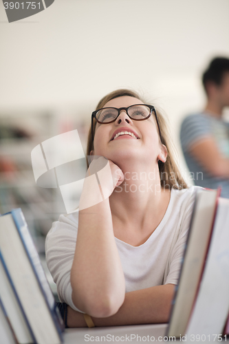 Image of portrait of famale student selecting book to read in library