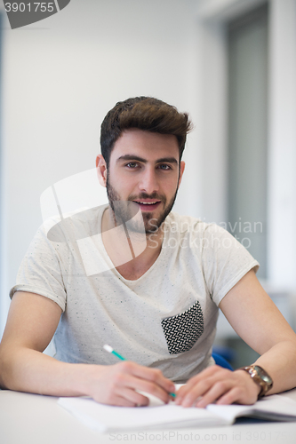 Image of male student taking notes in classroom