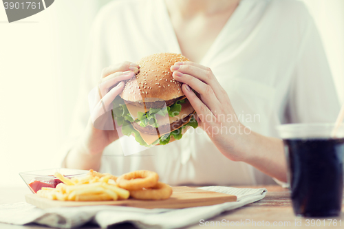 Image of close up of woman hands holding hamburger