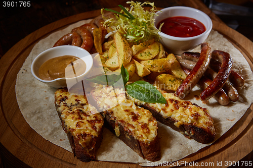 Image of Assorted fried sausages, grilled potatoes, sauce Adjika, Mustard Sauce