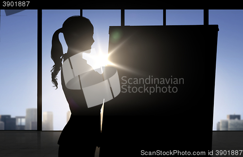 Image of silhouette of woman with flipboard over office