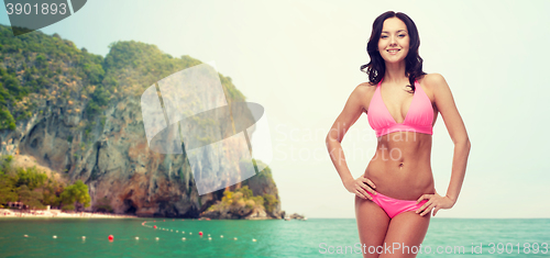 Image of happy young woman in pink bikini swimsuit