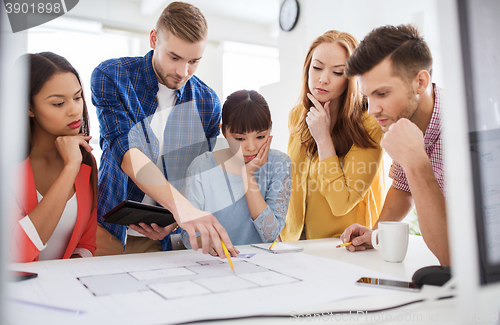 Image of creative team with blueprint working at office