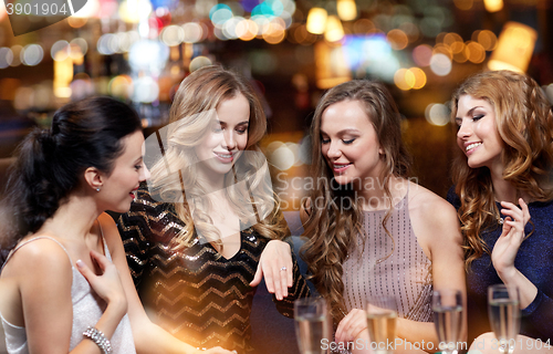 Image of woman showing engagement ring to her friends