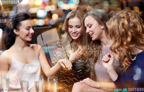 Image of woman showing engagement ring to her friends