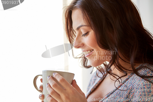 Image of happy woman with cup of tea or coffee at home