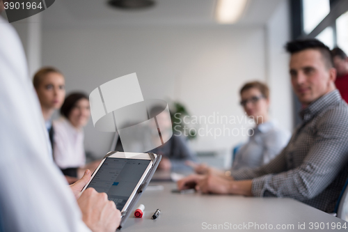 Image of close up of  businessman hands  using tablet on meeting