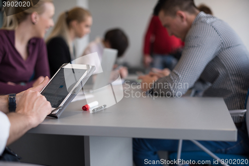 Image of close up of  businessman hands  using tablet on meeting