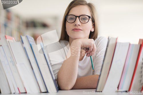 Image of portrait of famale student selecting book to read in library