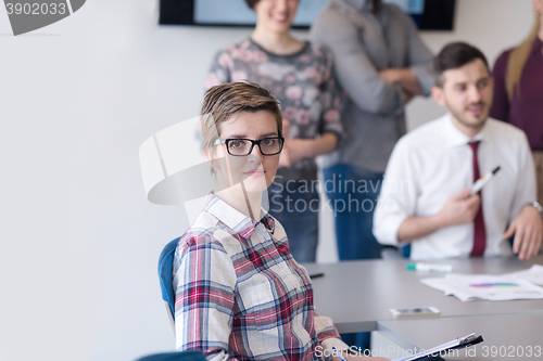 Image of portrait of young business woman at office with team on meeting 