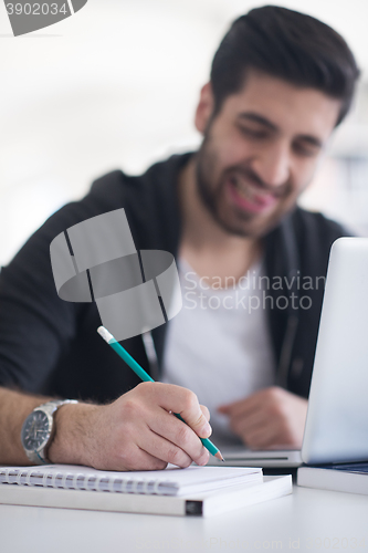 Image of student in school library using laptop for research