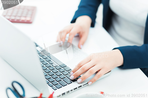 Image of The female hands on the keyboard of her laptop computer