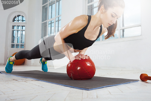 Image of Beautiful slim brunette doing some gymnastics at the gym