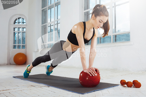 Image of Beautiful slim brunette doing some gymnastics at the gym