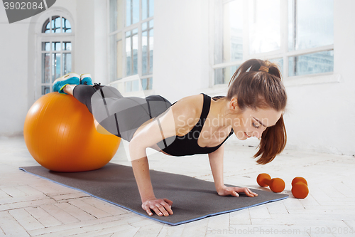 Image of Beautiful slim brunette doing some gymnastics at the gym