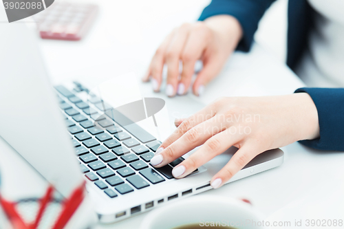 Image of The female hands on the keyboard of her laptop computer