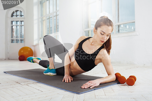 Image of Beautiful slim brunette  doing some push ups a the gym