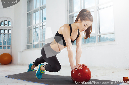 Image of Beautiful slim brunette doing some gymnastics at the gym