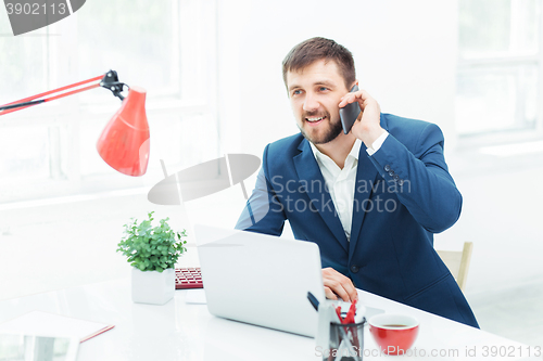 Image of Portrait of businessman talking on phone in office