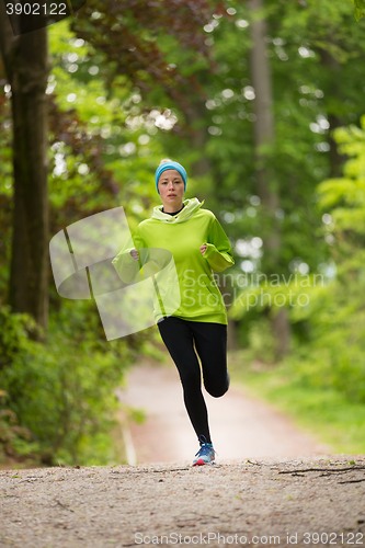 Image of Sporty young female runner in the forest. 