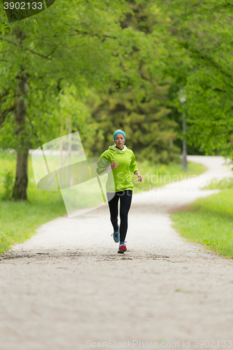 Image of Sporty young female runner in city park.. 