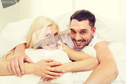 Image of happy couple in bed at home