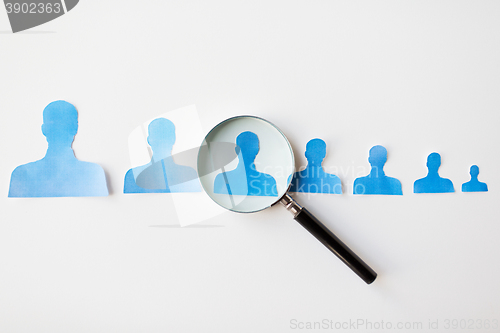 Image of close up of paper human shapes on white board