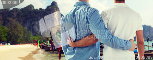 Image of close up of male gay couple hugging on beach