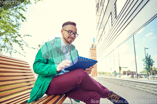 Image of happy young hipster man with tablet pc and bike