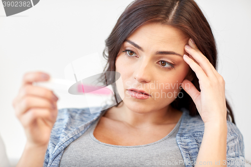 Image of sad woman looking at home pregnancy test