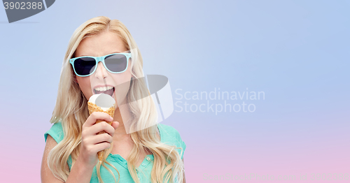 Image of happy young woman in sunglasses eating ice cream