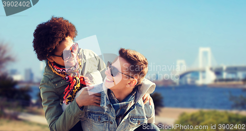 Image of happy teenage couple in shades having fun outdoors