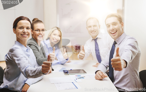 Image of business team showing thumbs up in office