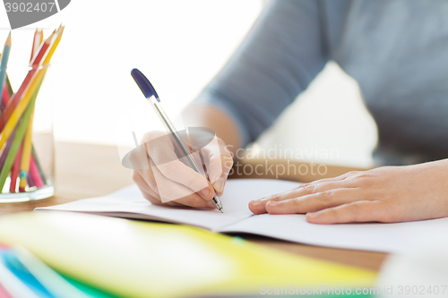 Image of close up of student writing to notebook at home