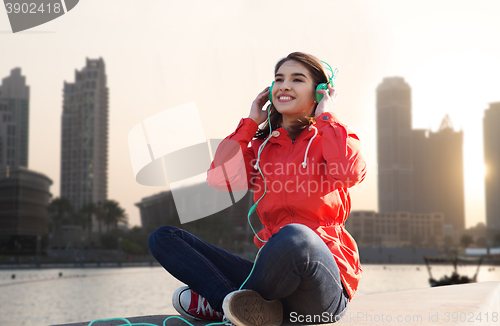 Image of happy young woman in headphones listening to music