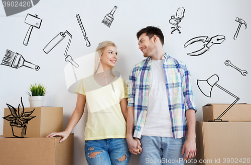 Image of smiling couple with big boxes moving to new home