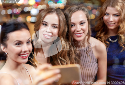 Image of women with smartphone taking selfie at night club