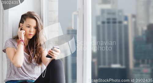 Image of teenage girl with smartphone and earphones