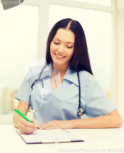 Image of female doctor or nurse writing prescription