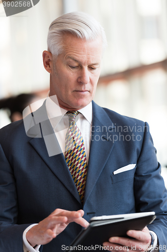 Image of senior business man working on tablet computer